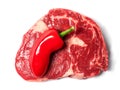 Fresh raw ribeye steak with one red chilly pepper. White isolated background, Royalty Free Stock Photo