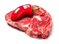 Fresh raw ribeye steak with one red chilly pepper. White isolated background Royalty Free Stock Photo