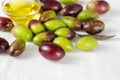Fresh raw ripe green and black olives and cold pressed oil bowl closeup on linen tablecloth Royalty Free Stock Photo