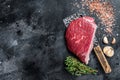 Fresh Raw rump beef cut or top sirloin cap steak on butcher cleaver. Black background. Top view. Copy space Royalty Free Stock Photo