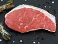 fresh raw rump meat cut from the picanha cap on a black slate plate with salt, pepper and bundle of spices Royalty Free Stock Photo