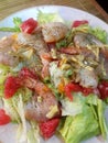 Fresh raw  salad with lettuce, tiger  shrimps and grapefruit  with sour sauce at pink plate. close up Royalty Free Stock Photo
