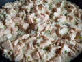 Fresh and raw salmon fillet cut in small pieces cooking on hot pan with olive oil, green onions and sour cream Royalty Free Stock Photo