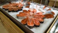 Fresh raw salmon fillet on ice on the counter in a fish store. red fish fillets in the glass refrigerator is sold in the Royalty Free Stock Photo