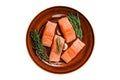 Fresh Raw salmon fish fillet steaks on rustic plate with thyme and rosemary. Isolated on white background. Royalty Free Stock Photo