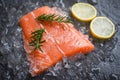 Fresh raw salmon fish steak on ice with rosemary food lemon and dark stone background Royalty Free Stock Photo