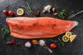 Fresh raw salmon fish steak with spices on dark stone background. Creative layout made of fish, top view, flat lay Royalty Free Stock Photo