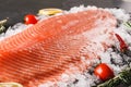 Fresh raw salmon fish steak with spices on ice over dark stone background. Creative layout made of fish, macro Royalty Free Stock Photo