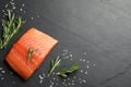 Fresh raw salmon and ingredients for marinade on black table, flat lay. Space for text Royalty Free Stock Photo