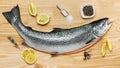 Fresh raw salmon, red fish with spices, salt, lemon, pepper, rosemary on wooden background. salmon cooking. Sea fish, healthy food Royalty Free Stock Photo