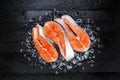 Fresh raw salmon red fish steak on ice on black wooden table top view Royalty Free Stock Photo