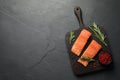 Fresh raw salmon and spices on black table, top view. Space for text Royalty Free Stock Photo