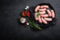 Fresh raw sausages on a cast-iron grill pan on a black background Royalty Free Stock Photo