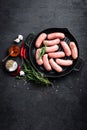 Fresh raw sausages on a cast-iron grill pan on a black background Royalty Free Stock Photo