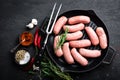 Fresh raw sausages on a cast-iron grill pan on a black background Royalty Free Stock Photo