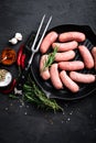 Fresh raw sausages on a cast-iron grill pan on a black background Royalty Free Stock Photo