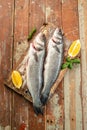 Fresh raw sea bass on a wooden background. vertical image. top view. place for text Royalty Free Stock Photo
