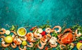 Fresh raw seafood - shrimps and crabs with herbs and spices on turquoise background. Copy space Royalty Free Stock Photo