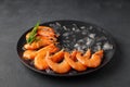 Fresh raw shrimp with ice on a black plate. Royalty Free Stock Photo