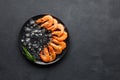 Fresh raw shrimp with ice on a black stone background. Royalty Free Stock Photo