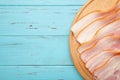 Fresh raw sliced bacon on the wooden cutting board on blue Royalty Free Stock Photo