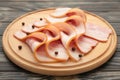 Fresh raw sliced bacon on the wooden cutting board on brown background Royalty Free Stock Photo