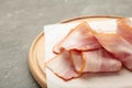 Fresh raw sliced bacon on the wooden cutting board on grey Royalty Free Stock Photo