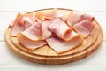 Fresh raw sliced bacon on the wooden cutting board on white Royalty Free Stock Photo