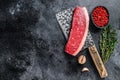 Fresh Raw top sirloin beef meat steak on a butcher cleaver. Dark wooden background. Top view. Copy space Royalty Free Stock Photo