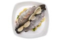 Fresh, raw two trout lying on a plate, stuffed with butter, onion, parsley and lemon slices, isolated on a white background with a Royalty Free Stock Photo