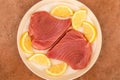 Fresh Raw Uncooked Yellow Fin Tuna Steaks With Lemon Slices