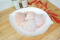 Fresh Raw Upper Thigh of Chicken on a White plate and seasoning Royalty Free Stock Photo