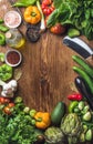 Fresh raw vegetable ingredients for healthy cooking or salad making on wooden background, copy space in center, top view Royalty Free Stock Photo