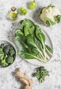 Fresh raw vegetables - chard, broccoli, cauliflower, peppers, olive oil and ginger on a light background Royalty Free Stock Photo