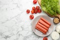 Fresh raw vegetarian sausages, soybeans and vegetables on white marble table, flat lay. Space for text Royalty Free Stock Photo