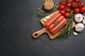 Fresh raw vegetarian sausages and vegetables on black table, flat lay. Space for text Royalty Free Stock Photo