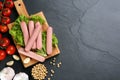 Fresh raw vegetarian sausages and vegetables on black table, flat lay. Space for text Royalty Free Stock Photo