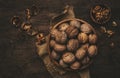 Fresh raw walnuts in bowl, autumn food background, nuts harvest. Old rustic wooden background, top view Royalty Free Stock Photo