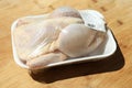 Fresh raw whole chicken in plastic container on wooden table Royalty Free Stock Photo