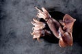 Fresh raw whole squid on a dark granite background. Top view. Copy space. Royalty Free Stock Photo