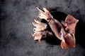 Fresh raw whole squid on a dark granite background. Top view. Copy space. Royalty Free Stock Photo
