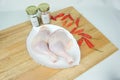 Fresh Raw Whole Thigh Chicken on a White plate and seasoning Royalty Free Stock Photo