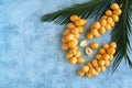 Fresh raw yellow dates with palm leaf on blue background. Top view