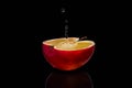 Fresh red apple with droplets of water against black background reflection drops fresh splash action movement Royalty Free Stock Photo
