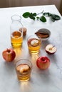 Fresh red apples and apple juice in glasses and bottle on a light background. Fruits and drinks. Top view, copy space.