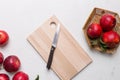 Fresh red apples with green leaves on table. cutting board with knife. Top view