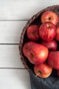 Fresh red apples in a wicker basket. Ripe fruits as a concept of a plentiful harvest. White background