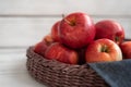 Fresh red apples in a wicker basket. Ripe fruits as a concept of a plentiful harvest. White background