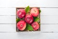 Fresh red apples in a wooden box. Organic food. On a white wooden background. Royalty Free Stock Photo