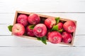 Fresh red apples in a wooden box. Organic food. On a white wooden background. Royalty Free Stock Photo